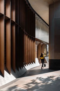Rear view of woman walking in corridor of building