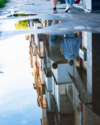 Reflection of people on puddle in city