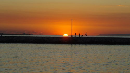 Silhouette of people on beach during sunset