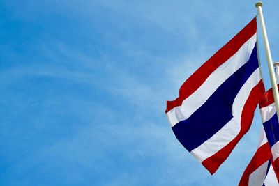 Low angle view of flag against blue sky