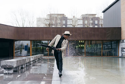 Man with umbrella standing in rain