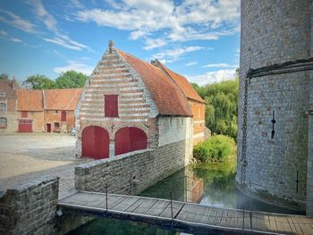 View of castle by river against sky