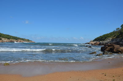 Scenic view of beach against blue sky