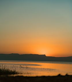 Scenic view of sea against clear sky during sunset