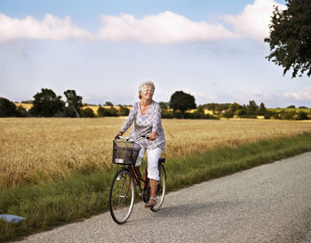 Full length of woman with umbrella on road
