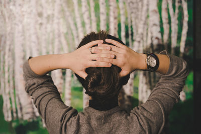 Rear view of young woman with hand in hair