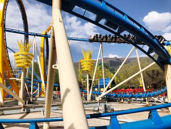 Low angle view of chain swing ride against sky