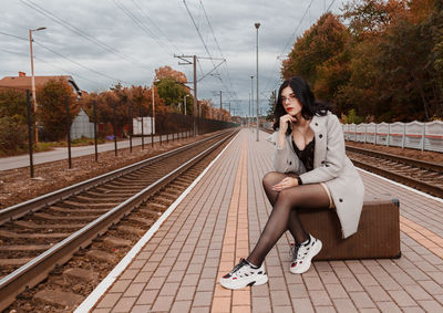 Woman sitting on railroad track