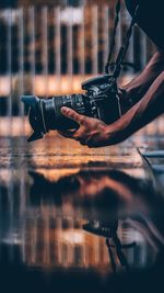 Cropped image of hands photographing through camera