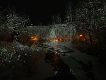 Frozen river against sky at night during winter