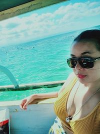 Portrait of woman in sunglasses against sea