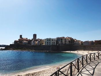 View of buildings by sea against clear sky