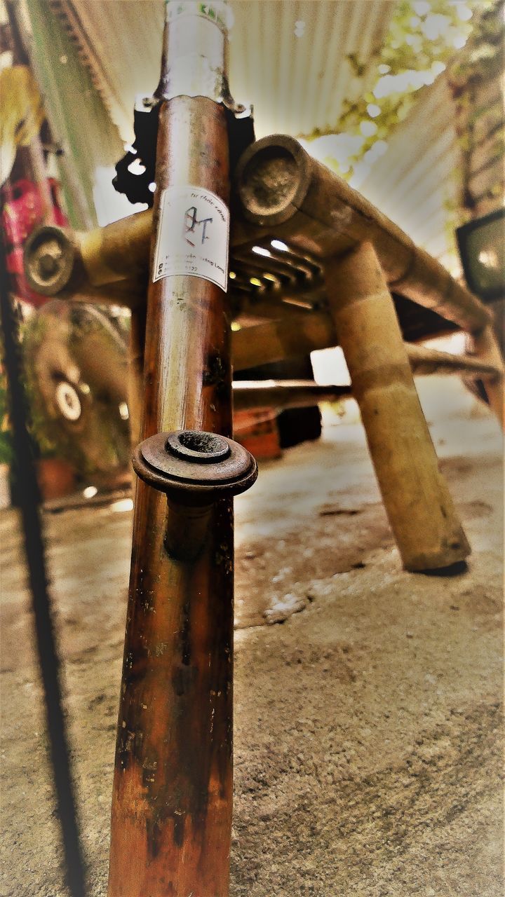 CLOSE-UP OF RUSTY PIPE ON METAL