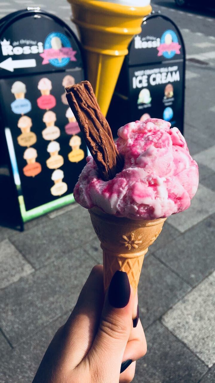 CLOSE-UP OF HAND HOLDING ICE CREAM