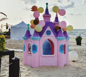 Multi colored umbrellas on beach by sea against sky