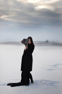 Full length of woman standing on beach against sky