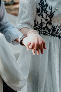 Midsection of couple holding hands