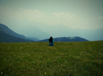 Scenic view of grassy field against cloudy sky