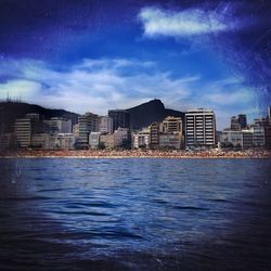 Buildings in city against blue sky