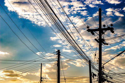 Low angle view of silhouette electricity pylon against sky during sunset