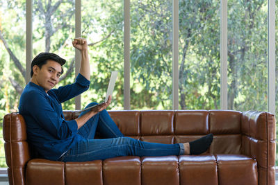 Happy young woman sitting on sofa