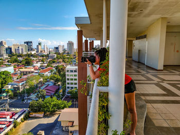 People standing by buildings in city against sky