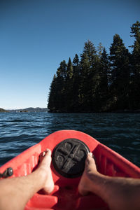 Midsection of person against sea against clear sky