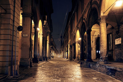 Illuminated alley amidst buildings