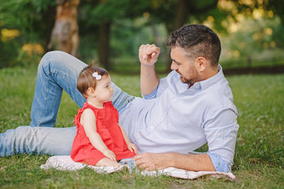 Mother and daughter sitting on grass