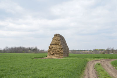 Hay bales on field against sky