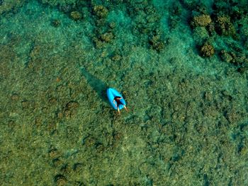 Aerial view of man over inflatable raft in sea
