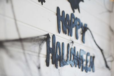 Close-up of happy halloween text against wall