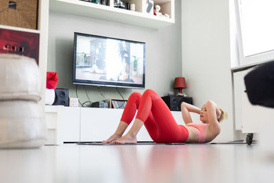 Midsection of woman sitting on floor at home