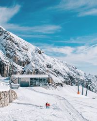 People on snowcapped mountain against sky