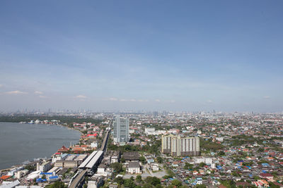High angle view of buildings by river against sky