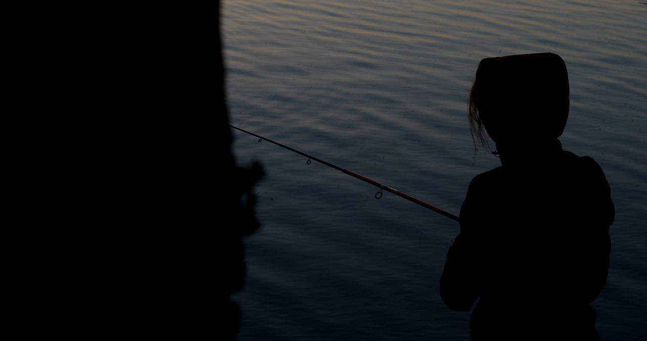 SILHOUETTE MAN FISHING AT LAKE