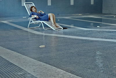 Side view of man sitting on street