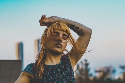 Portrait of teenage girl wearing sunglasses against sky