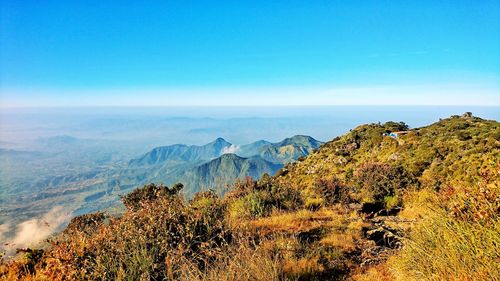 Scenic view of landscape and mountains against clear blue sky