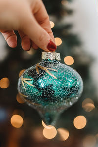 Close-up of hand holding illuminated christmas lights