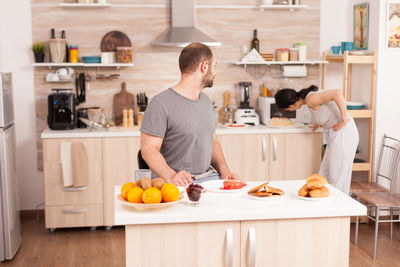 Man and woman working in kitchen at home