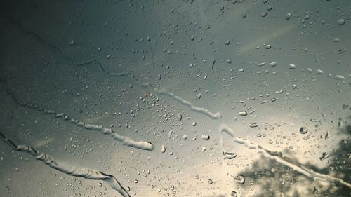 Close-up of waterdrops on glass against clear sky