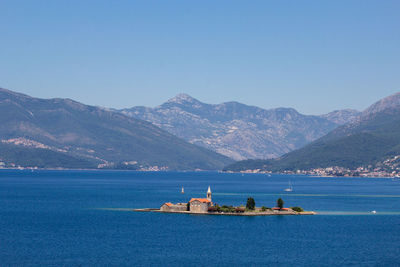 Scenic view of island and mountains against clear sky