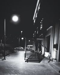 Empty street amidst buildings at night