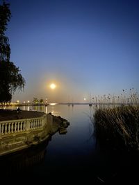 Scenic view of lake against clear blue sky at night