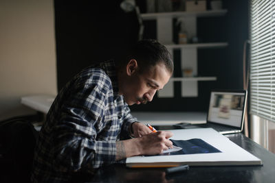 Tattoo artist working in his studio