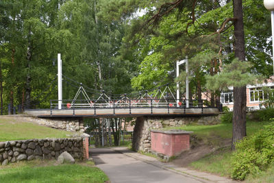 Bridge over road amidst trees in forest