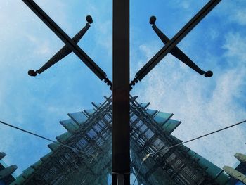 Low angle view of crane against cloudy sky