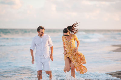 Rear view of couple standing at beach