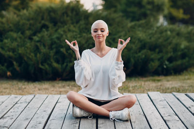 Portrait of young woman sitting on bench